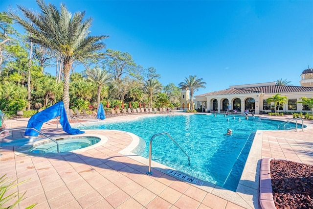 view of swimming pool with a patio area and a hot tub