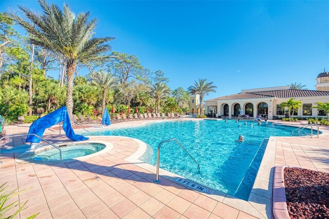 view of pool with a patio area and a hot tub