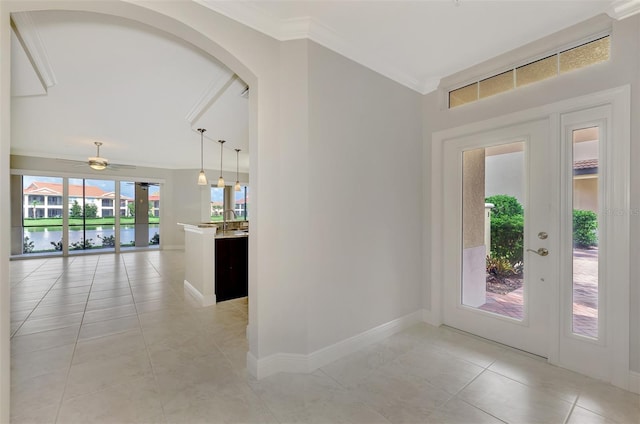 tiled foyer with a water view, ceiling fan, and ornamental molding