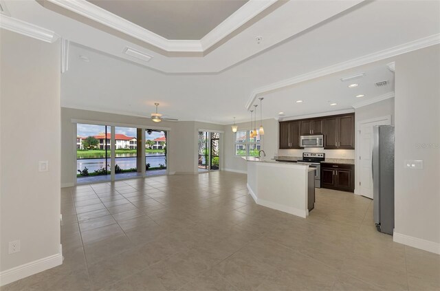 kitchen with ceiling fan, a kitchen island with sink, dark brown cabinets, appliances with stainless steel finishes, and ornamental molding