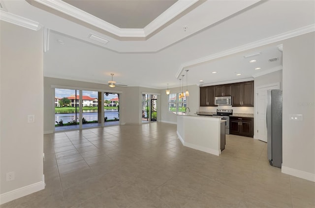 kitchen with crown molding, a center island with sink, plenty of natural light, and appliances with stainless steel finishes