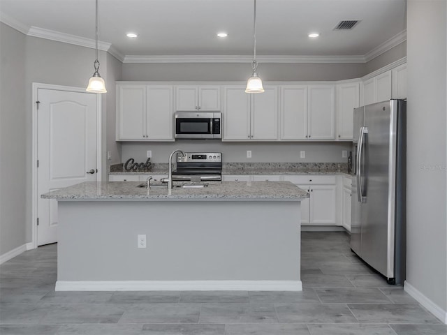 kitchen with an island with sink, appliances with stainless steel finishes, pendant lighting, and white cabinets