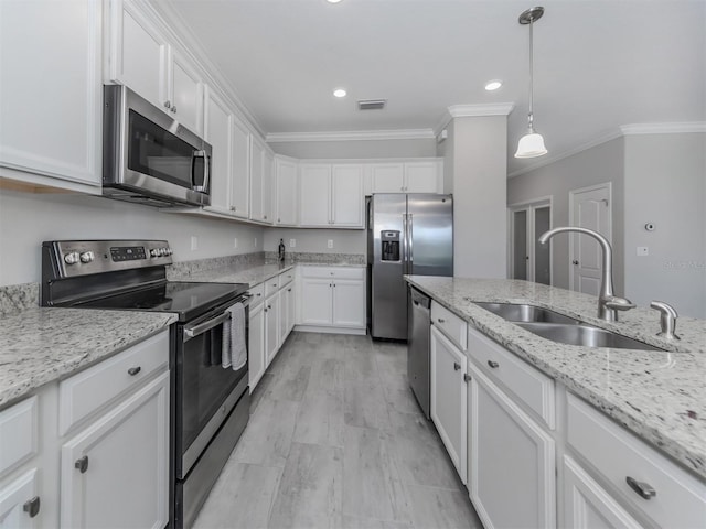 kitchen with sink, hanging light fixtures, stainless steel appliances, ornamental molding, and white cabinets