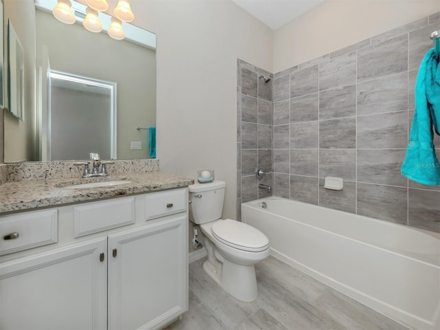 full bathroom featuring tiled shower / bath combo, vanity, a notable chandelier, and toilet