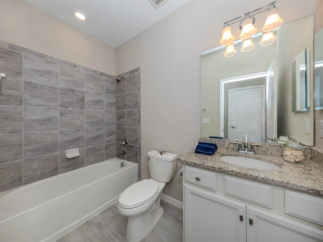 full bathroom featuring tiled shower / bath, vanity, and toilet