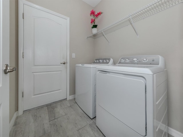 laundry room with separate washer and dryer and light wood-type flooring