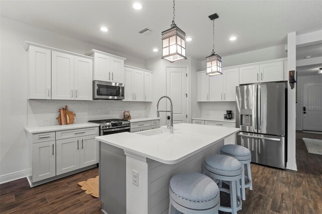 kitchen with appliances with stainless steel finishes, backsplash, dark hardwood / wood-style floors, and sink