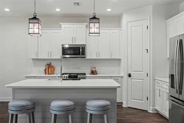 kitchen with white cabinets, dark wood-type flooring, and stainless steel appliances