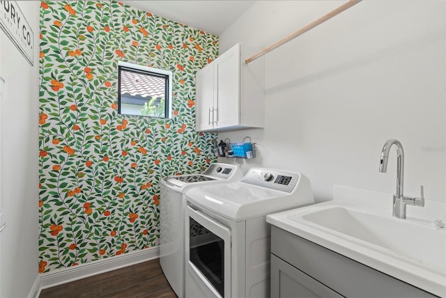 washroom featuring dark hardwood / wood-style floors, washing machine and dryer, cabinets, and sink