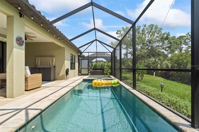 view of swimming pool with a lanai, an in ground hot tub, a patio, and ceiling fan