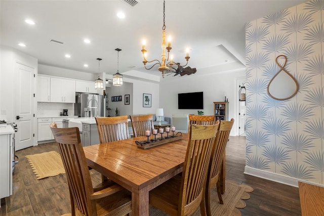 dining space with a tray ceiling, dark hardwood / wood-style flooring, and an inviting chandelier