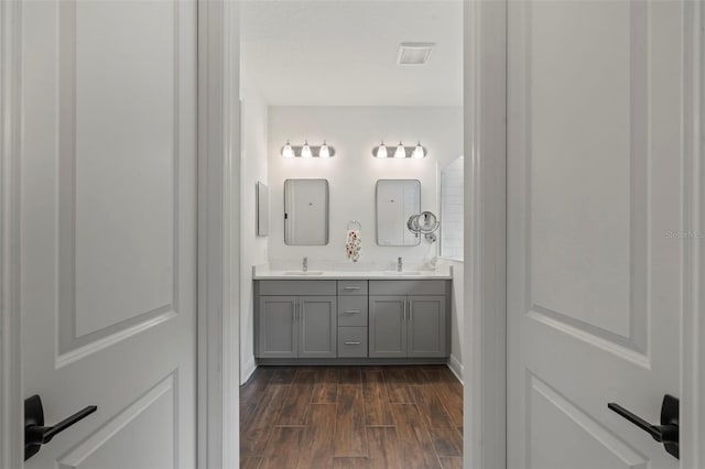 bathroom with dual vanity and hardwood / wood-style flooring