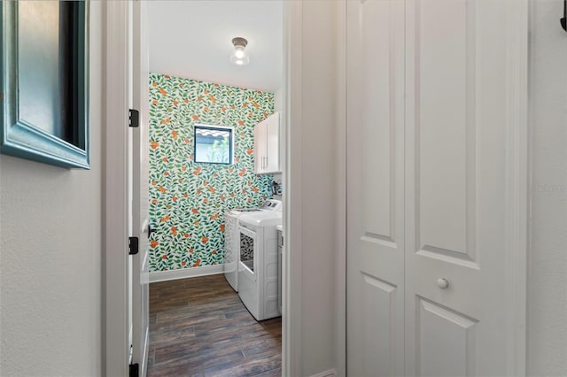 washroom with washing machine and clothes dryer, cabinets, and dark wood-type flooring