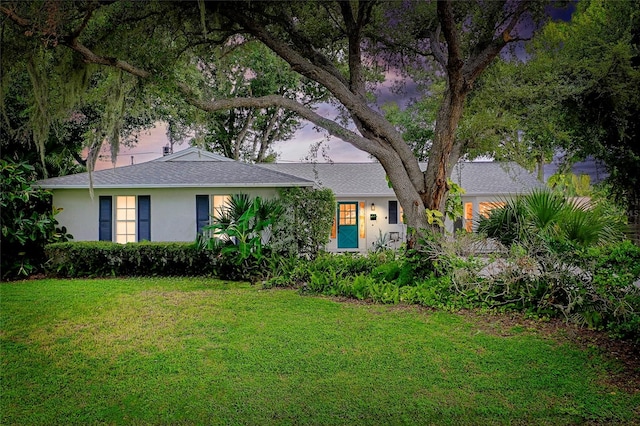 ranch-style home featuring a lawn