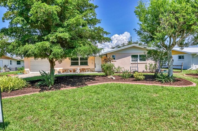 ranch-style house featuring a front lawn and a garage