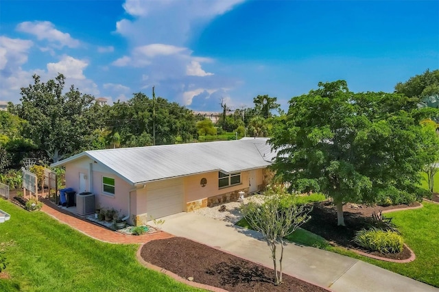 single story home with a garage, central AC unit, and a front lawn