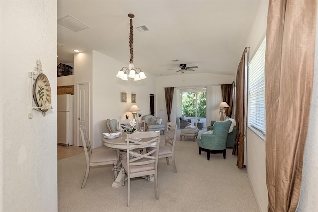 carpeted dining space with lofted ceiling and ceiling fan with notable chandelier