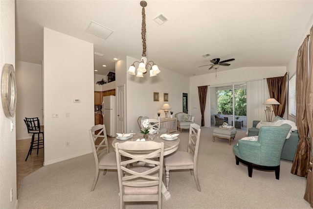 dining space with ceiling fan with notable chandelier, light colored carpet, and lofted ceiling