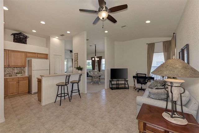 living room with plenty of natural light, ceiling fan with notable chandelier, and light tile patterned flooring