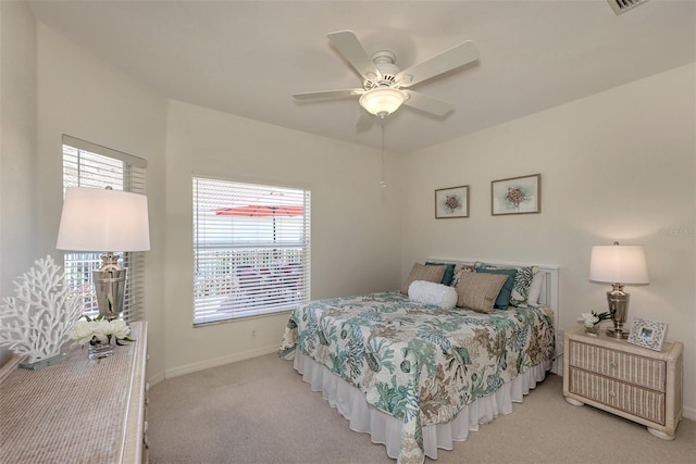 bedroom with ceiling fan, multiple windows, and light carpet