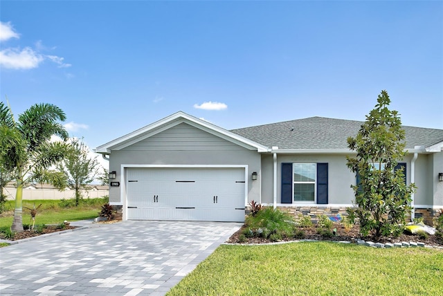 ranch-style house featuring stone siding, an attached garage, decorative driveway, a front lawn, and stucco siding