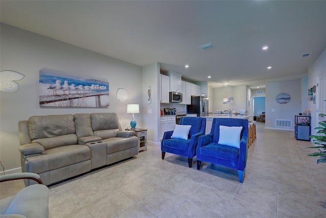 living area featuring baseboards, visible vents, and recessed lighting