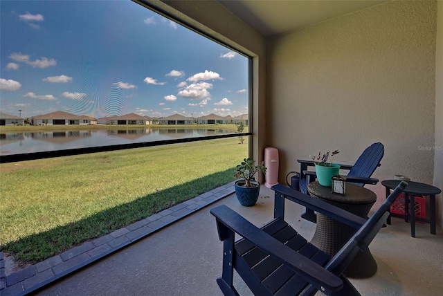 sunroom / solarium featuring a water view