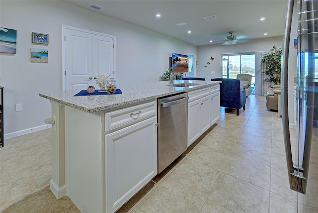 kitchen featuring visible vents, light stone counters, a kitchen island with sink, white cabinetry, and stainless steel dishwasher