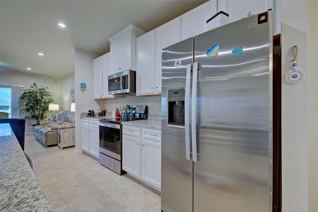 kitchen featuring white cabinetry, appliances with stainless steel finishes, open floor plan, and recessed lighting