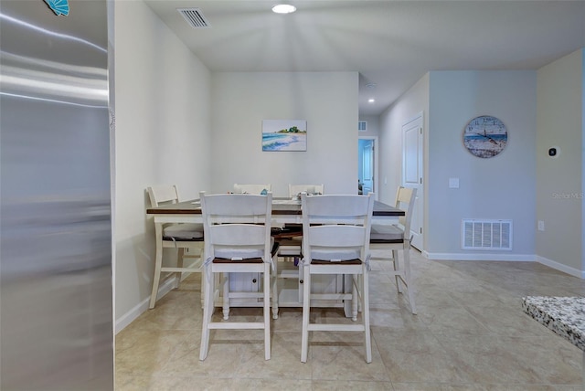 tiled dining area with visible vents and baseboards