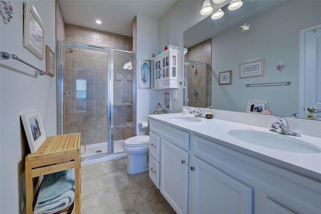 bathroom featuring toilet, a shower stall, and a sink