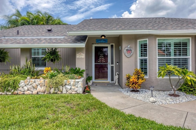 view of exterior entry featuring a yard