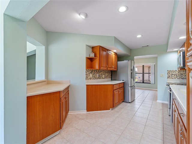 kitchen featuring tasteful backsplash, appliances with stainless steel finishes, and light tile patterned floors