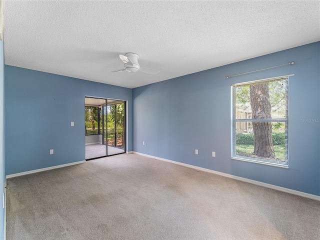 carpeted spare room featuring ceiling fan and a textured ceiling