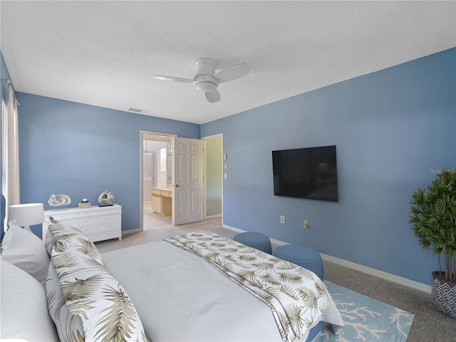 bedroom with light carpet, a textured ceiling, connected bathroom, and ceiling fan