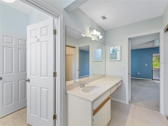 bathroom featuring a textured ceiling, tile patterned floors, and vanity