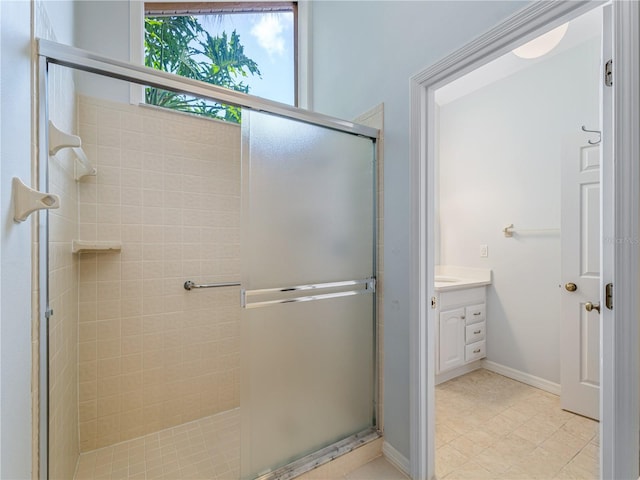 bathroom featuring a shower with door, vanity, and tile patterned flooring