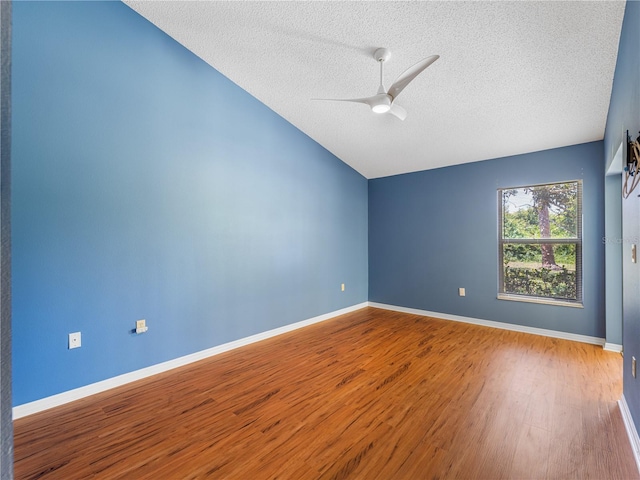 unfurnished room featuring ceiling fan, a textured ceiling, vaulted ceiling, and wood-type flooring