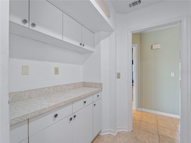 kitchen with white cabinets and light tile patterned floors