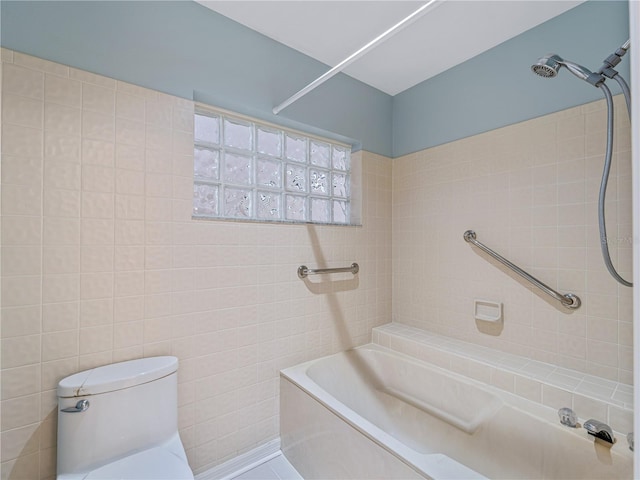 bathroom with tile walls, tiled shower / bath, and toilet