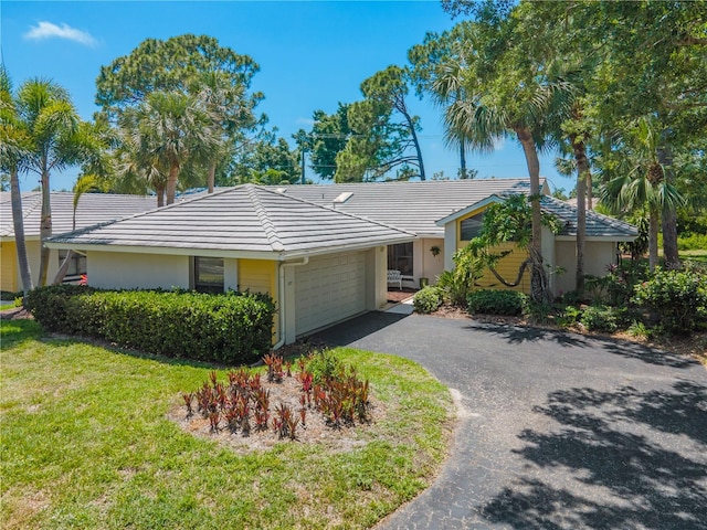 ranch-style home with a front lawn and a garage