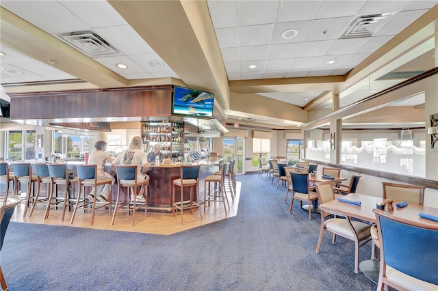 carpeted dining room with bar