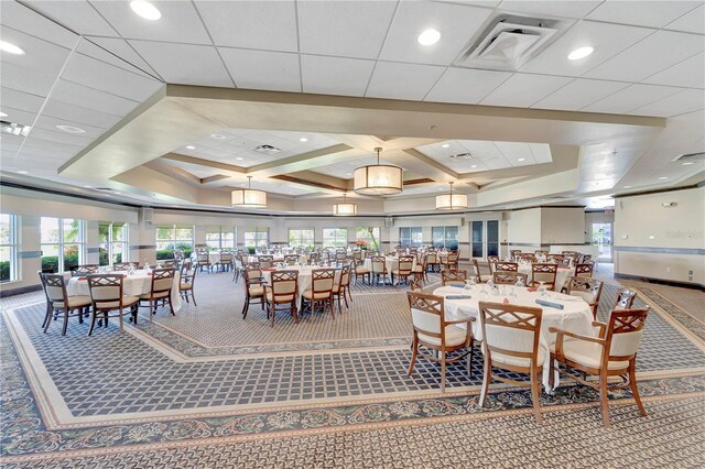 dining space featuring coffered ceiling, a raised ceiling, and carpet flooring