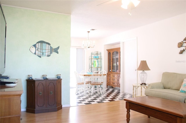 living room featuring ceiling fan with notable chandelier and wood-type flooring