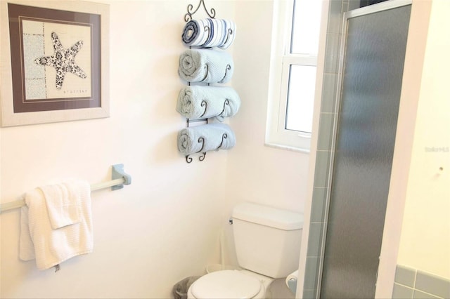 bathroom with toilet and an enclosed shower