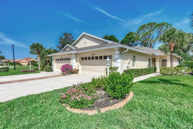 single story home featuring a garage, a front yard, concrete driveway, and stucco siding