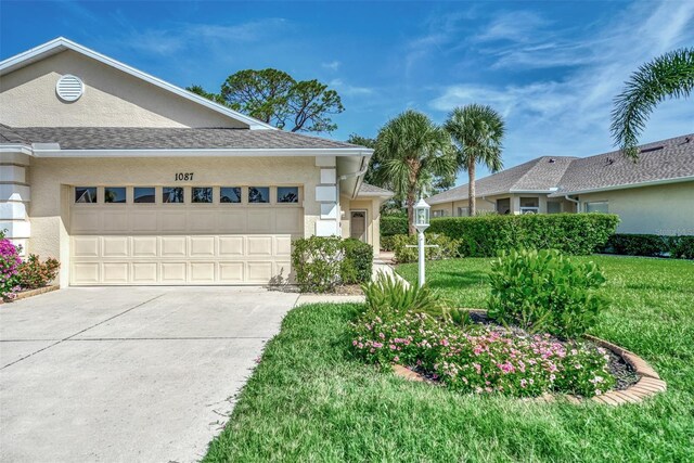 ranch-style home featuring a garage and a front lawn