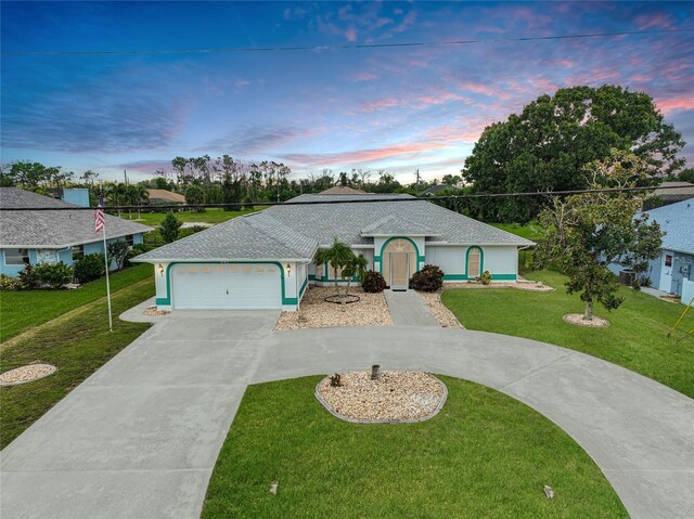 ranch-style home featuring a garage, a yard, and cooling unit