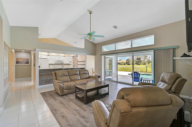 living room with ceiling fan, high vaulted ceiling, and light hardwood / wood-style floors