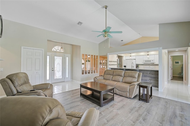 living room with light wood-type flooring, high vaulted ceiling, and ceiling fan